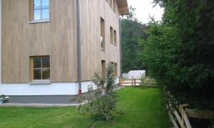 ein Haus mit einem Rasenplatz neben einem Gebäude in der Unterkunft Bergelemente im Hochwald in Schönau am Königssee