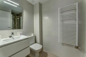 a bathroom with a toilet and a sink and a mirror at Hostal Lar in Burgos