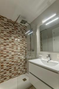 a bathroom with a tub and a sink and a mirror at Hostal Lar in Burgos