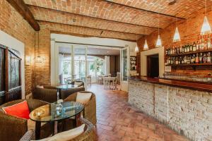 a restaurant with a brick wall and tables and chairs at La Villa Hotel in Mombaruzzo