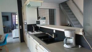 una cucina con lavandino e macchinetta del caffè di villa provençal avec piscine a vias de 10 personnes a Vias
