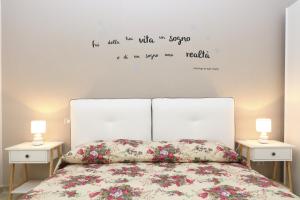 een slaapkamer met een bed met 2 nachtkastjes en 2 lampen bij La Casetta del Borgo Cefalù in Cefalù