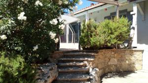 un sentiero in pietra di fronte a una casa con cespugli di villa provençal avec piscine a vias de 10 personnes a Vias