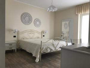 塔兰托Bed and Breakfast Sun Wine的一间带床和桌子的白色卧室