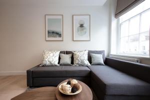 een woonkamer met een bank en een tafel bij Hampden Apartments - The George in Windsor