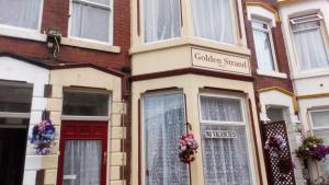 a house with a red door and a sign that reads gardenstand at MyRoomz Golden Strand Hotel in Blackpool