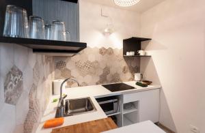uma pequena cozinha com um lavatório e um micro-ondas em Casa "Le Mura" 70mq em Riva del Garda