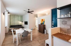 una sala da pranzo e un soggiorno con tavolo e sedie bianchi di Casa "Le Mura" 70mq a Riva del Garda