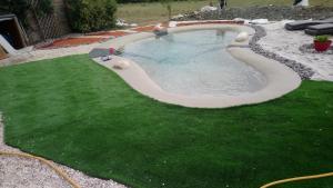 a swimming pool in a yard with green grass at Chambre d'hôtes de l'Estuaire de Blaye in Blaye