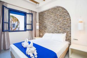 a bedroom with a bed and a brick wall at Christina Dream Village in Pastida +70 photos