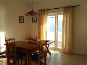 een eetkamer met een tafel en stoelen en een raam bij Panormitis Pizanias houses in Skaliá