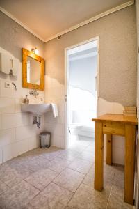 uma casa de banho com um lavatório, um espelho e uma mesa em Pension U Přístavu em Pomezí nad Ohří