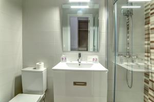 a bathroom with a toilet and a sink and a shower at Hostal Lar in Burgos