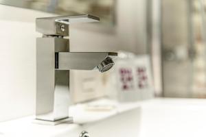 a metal faucet on a sink in a room at Hostal Lar in Burgos
