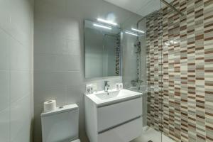 a bathroom with a sink and a toilet and a mirror at Hostal Lar in Burgos