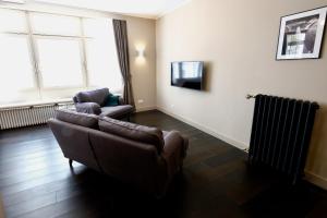 a living room with two couches and a television at Boutique Charme Apartment in Baden-Baden