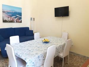 a dining room with a table and a blue couch at Penisola Apartment in Vico Equense