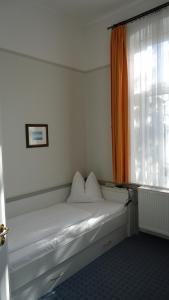 a bed in a room with a window at Hotel Fortuna in Heringsdorf