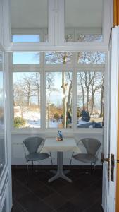 mesa y sillas en una habitación con ventana en Hotel Fortuna en Heringsdorf