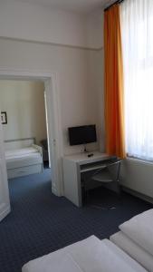 a hotel room with a desk with a computer on it at Hotel Fortuna in Heringsdorf