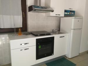 a white kitchen with a stove and a refrigerator at Confortable Apartment in Vasto in Vasto