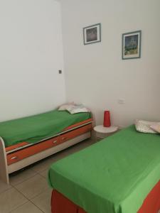 a bedroom with two beds with green sheets at Confortable Apartment in Vasto in Vasto