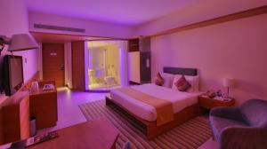 a hotel room with a large bed and a television at Hotel Parc Estique in Pune