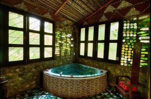 a large bath tub in a room with windows at Abezza Resort And Spa in Maskall