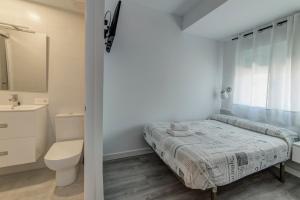 a bedroom with a bed and a toilet and a sink at Hostal Lar in Burgos