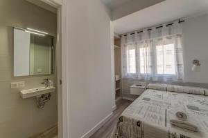 a bedroom with a bed and a sink and a mirror at Hostal Lar in Burgos