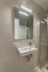 a white bathroom with a sink and a shower at Hostal Lar in Burgos