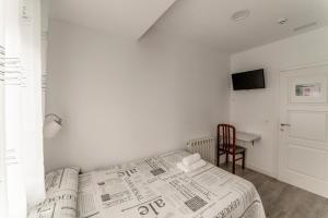 a bedroom with a bed with a newspaper on it at Hostal Lar in Burgos