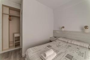 a white bedroom with a bed and a closet at Hostal Lar in Burgos