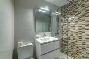 a bathroom with a sink and a toilet and a mirror at Hostal Lar in Burgos