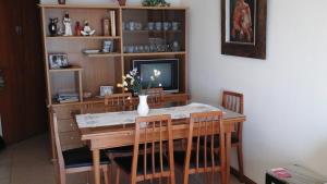 馬德普拉塔的住宿－Departamento en Mar del Plata，餐桌、椅子和花瓶