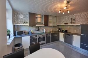 a kitchen with brown cabinets and a table with chairs at Ferienwohnung Haaren in Waldfeucht