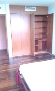 Habitación vacía con suelo de madera y mesa. en Juliana, en Recife