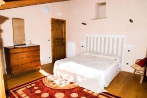 a bedroom with a bed and a dresser and a chair at Agriturismo Magnarosa in Barge