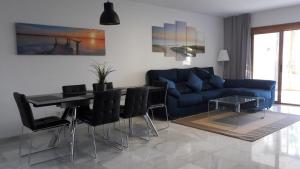 een woonkamer met een blauwe bank en een tafel bij El Velerín in Estepona