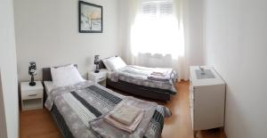 a bedroom with two beds and a window at Kasztanowa Apartament in Warsaw