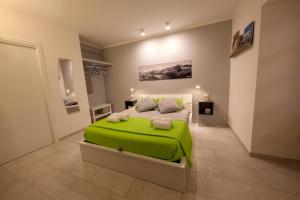 Cuasso Al MonteにあるVoi da Noi - Home Experienceのベッドルーム1室(緑色のベッド1台付)