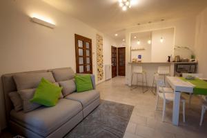Cuasso Al MonteにあるVoi da Noi - Home Experienceのリビングルーム(緑の枕とソファ付)