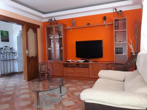 a living room with a couch and a tv at Casa de Campo Hiurma in Triquivijate