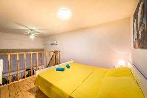 sypialnia z żółtym łóżkiem i balkonem w obiekcie Apartment Duci w Splicie