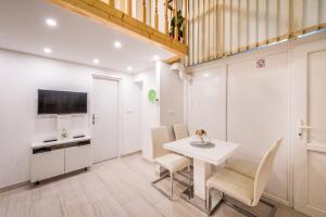 una cucina e una sala da pranzo con tavolo e sedie bianchi di Apartment Duci a Spalato (Split)