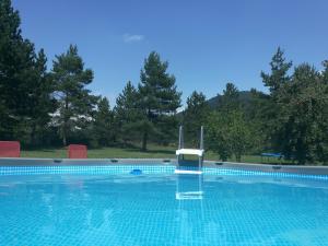 a swimming pool with a chair in the middle of it at Holiday Home Lana in Korenica