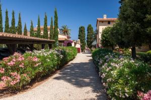 une passerelle traversant un jardin planté de fleurs et d'arbres dans l'établissement Tenuta La Chiusa, à Portoferraio