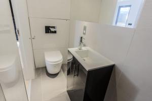 Un baño blanco con inodoro y lavabo. en Room Home Stay, en Londres 54 fotos más