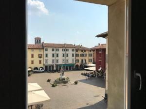 een raam met uitzicht op een binnenplaats met gebouwen bij Casa In Piazza in Cividale del Friuli