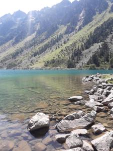 un lago di montagna con rocce in primo piano di Résidence Bellevue a Cauterets